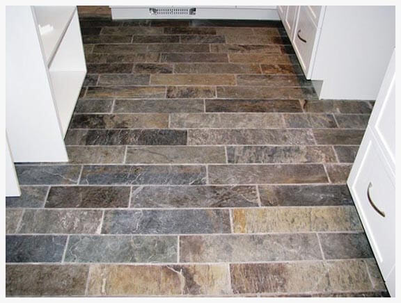 dining room with floor covered with slate board and white cabinet with gray handles