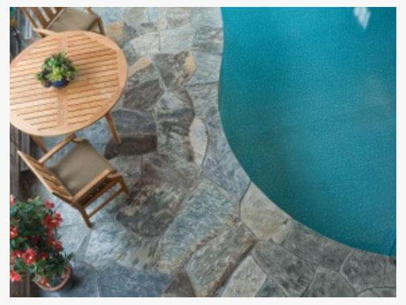 pool with wooden chair, wooden table with plant and slate in bulk